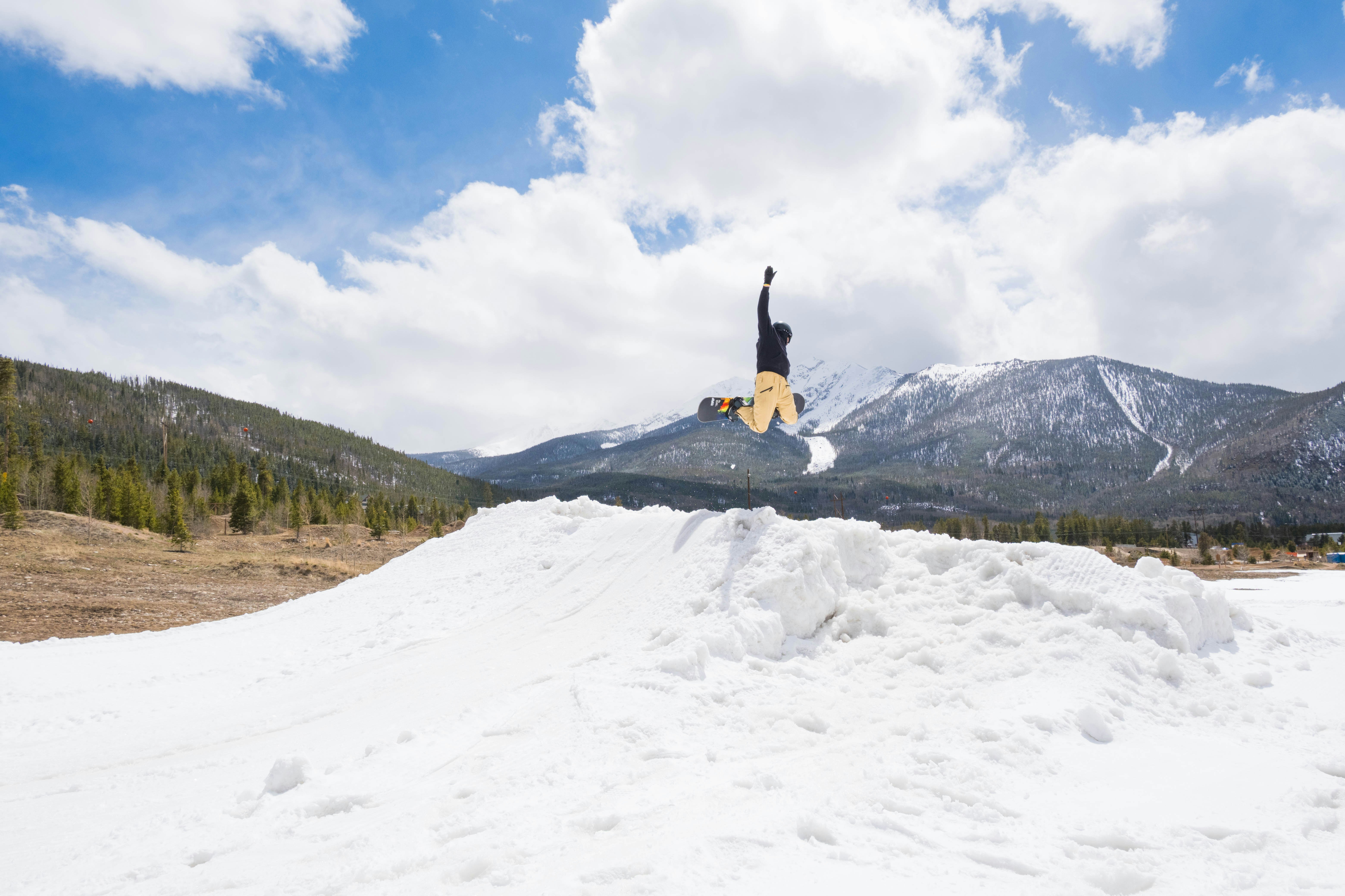 person in black jacket and blue denim jeans standing on snow covered ground during daytime